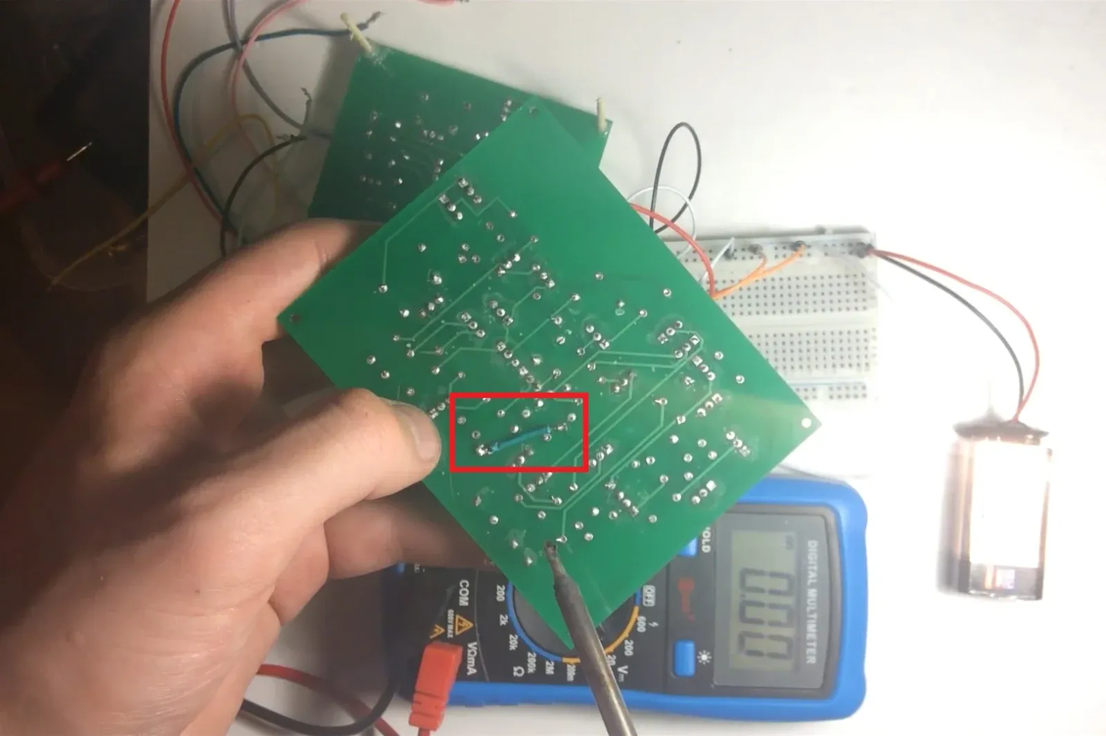 Underside of the green one-bit adder PCB showing the blue jumper wire used to ground R16
