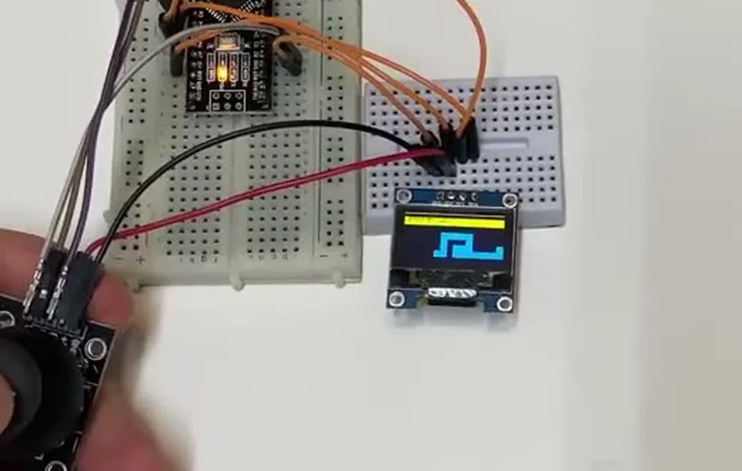 Arduino breadboard prototype running Snake on a small OLED while an analog joystick controls it