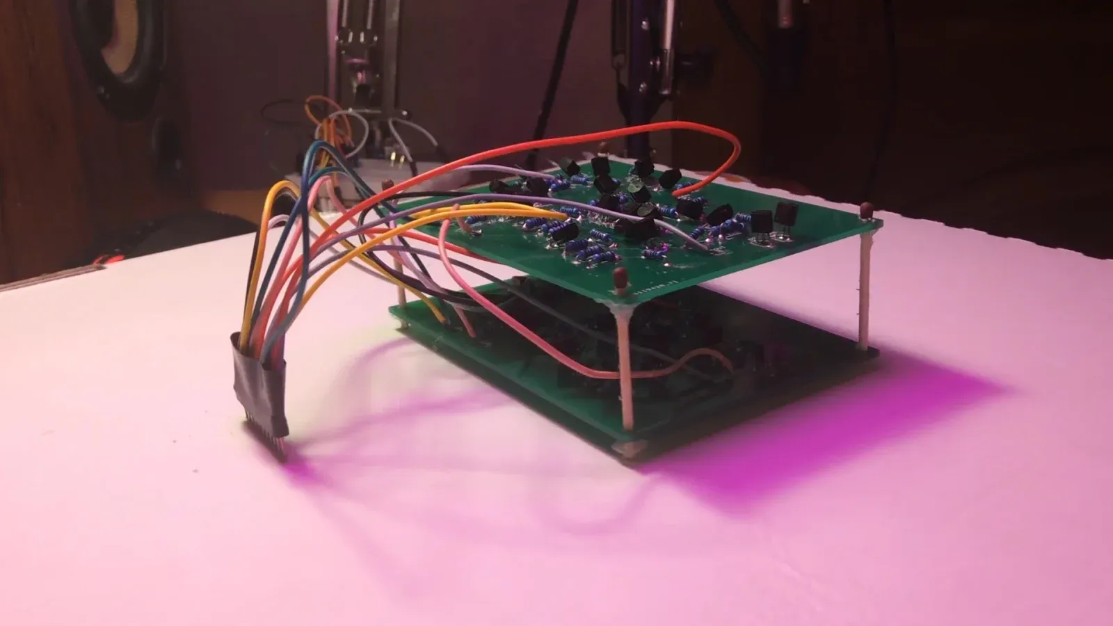 Two green one-bit adder PCBs stacked and connected with colored jumper wires